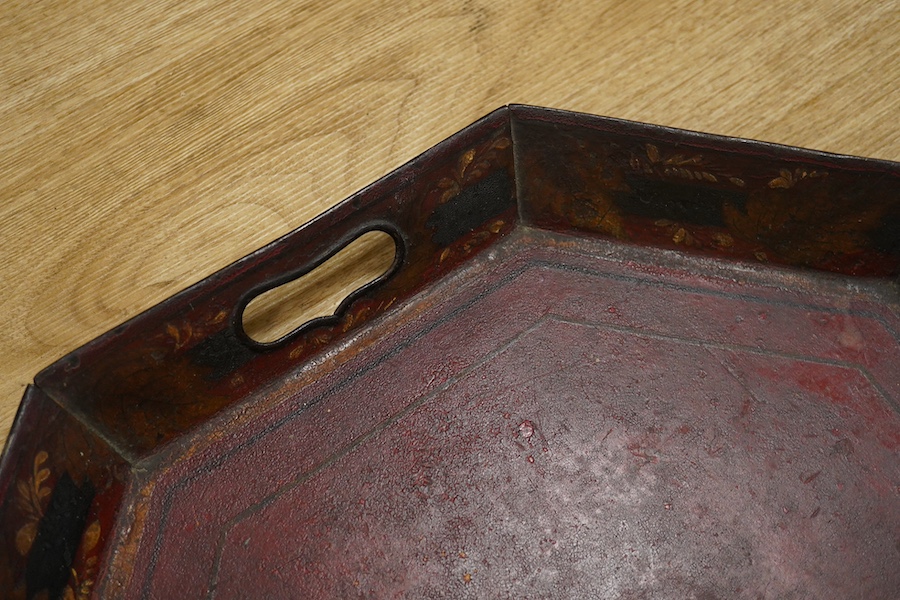 An early 19th century octagonal red painted toleware tray, possibly Pontypool, 66cm wide. Condition - poor